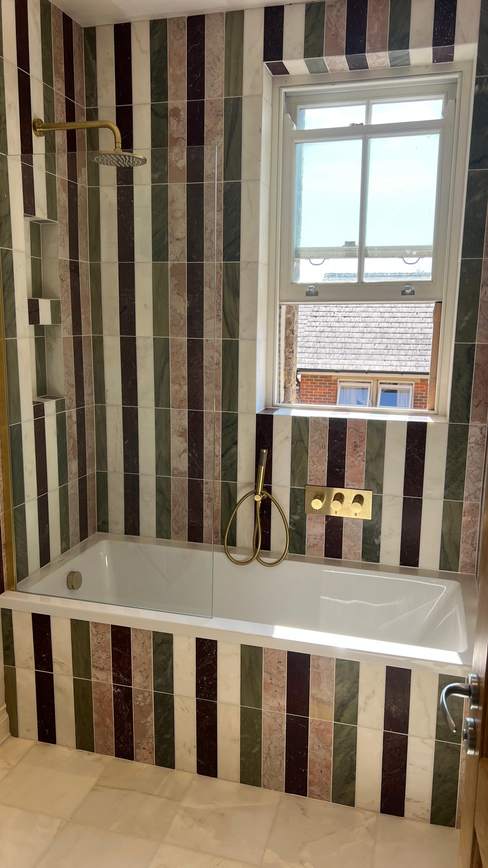 Bathroom with striped feature tiling and built-in bath