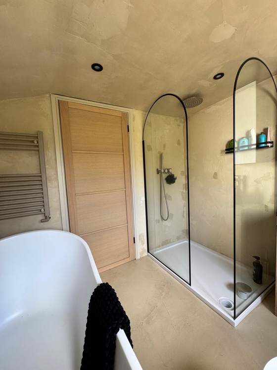Bathroom with freestanding bath and arched walk-in shower