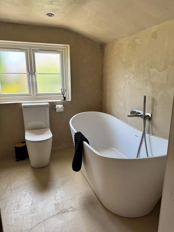 Freestanding bath in a polished-plaster bathroom
