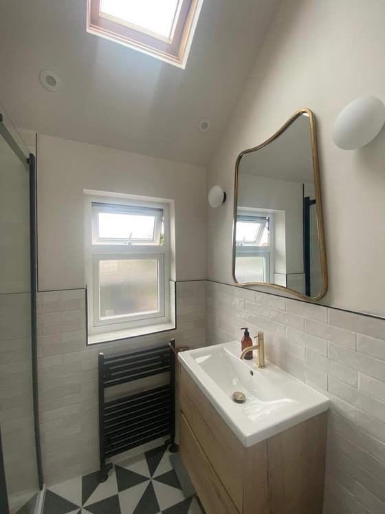 Bathroom with patterned floor tiles under a roof light